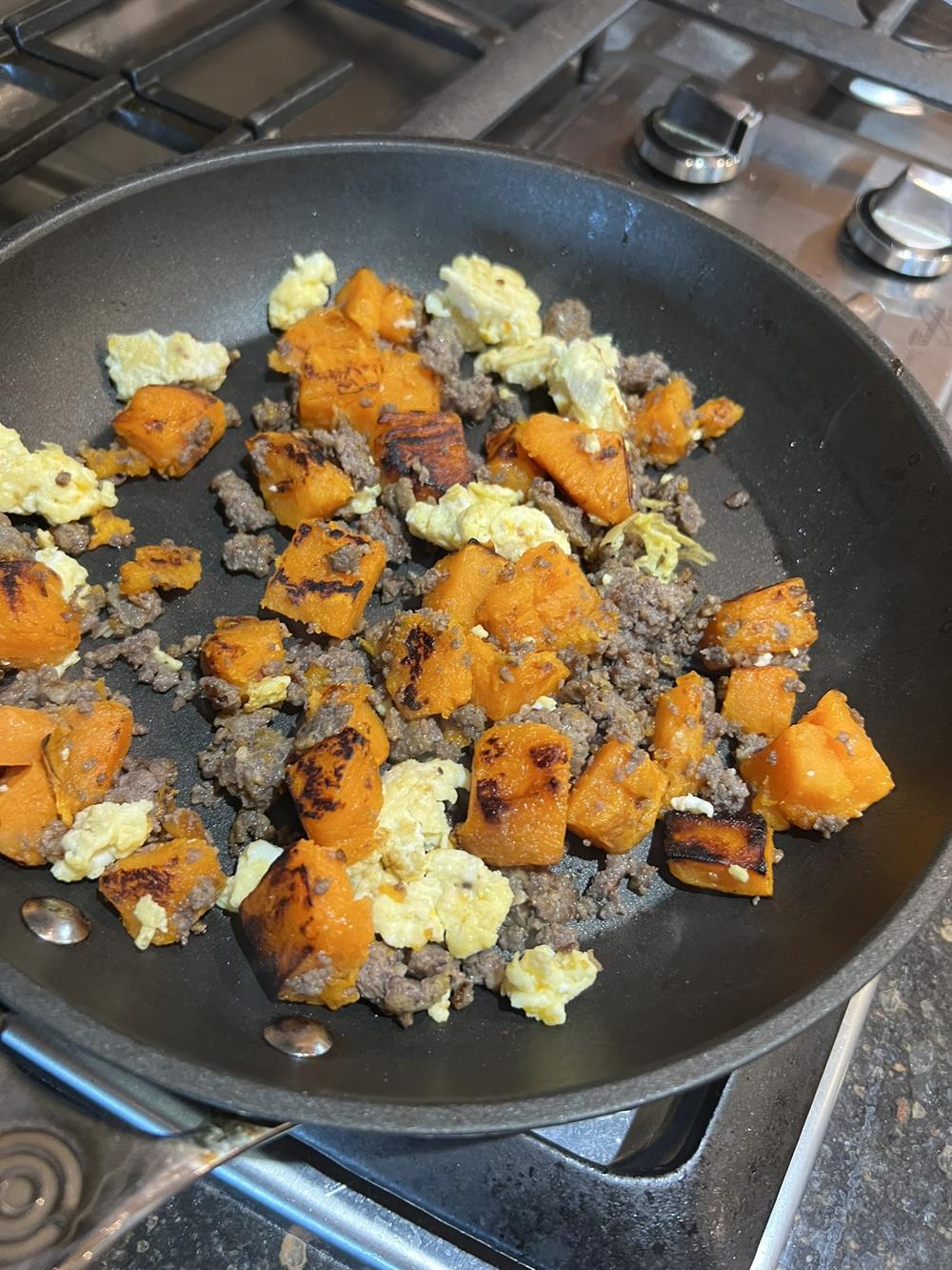 eggs, sweet potatoes, and sausage in pan on the stove