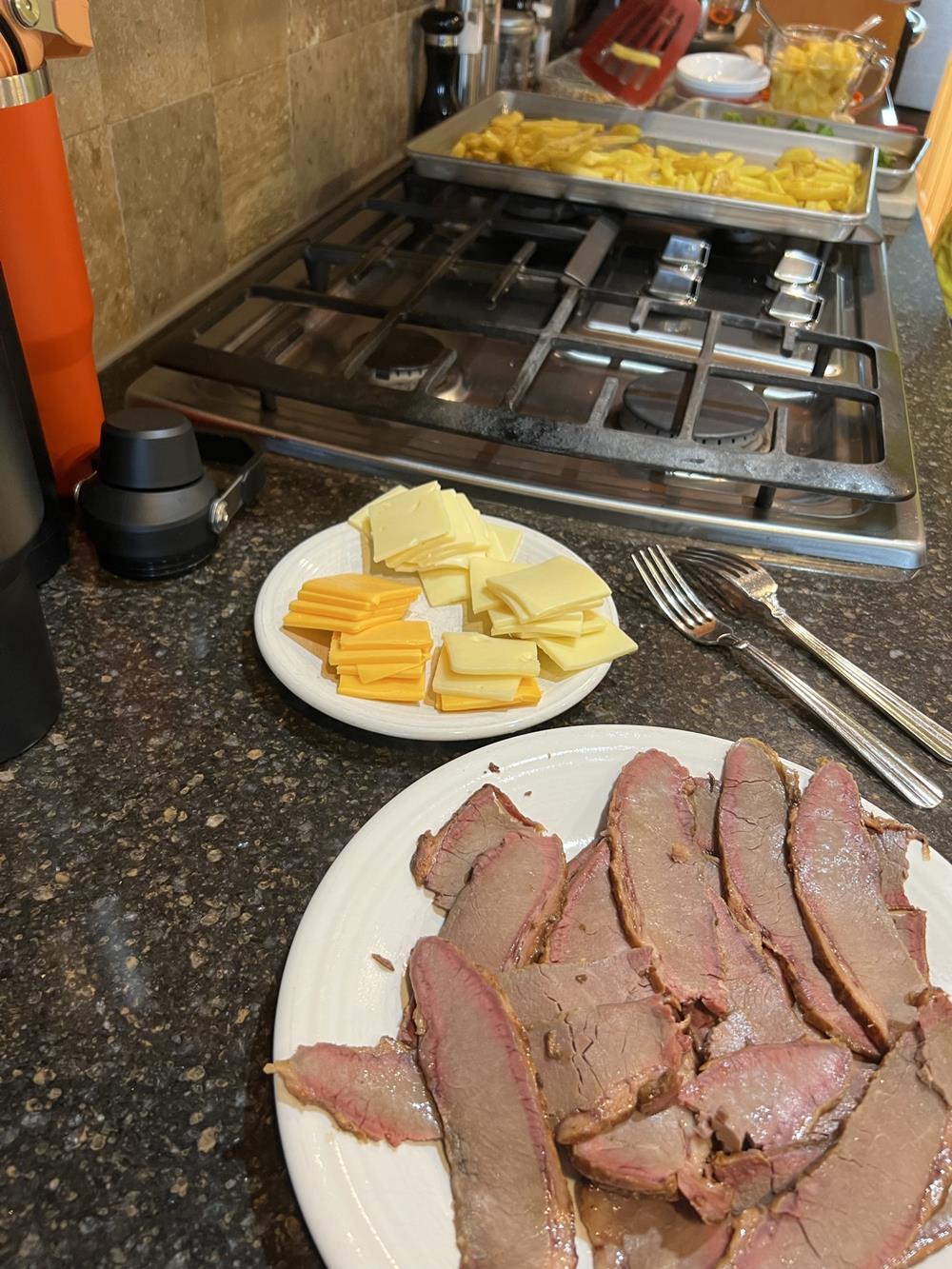 sliced brisket and cheese on white plates on counter