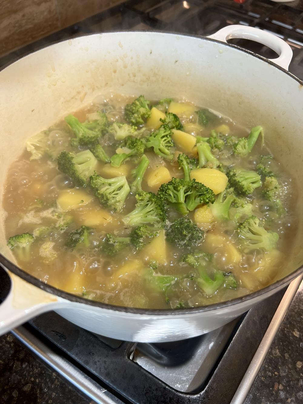 broccoli soup in a white pan on the stove