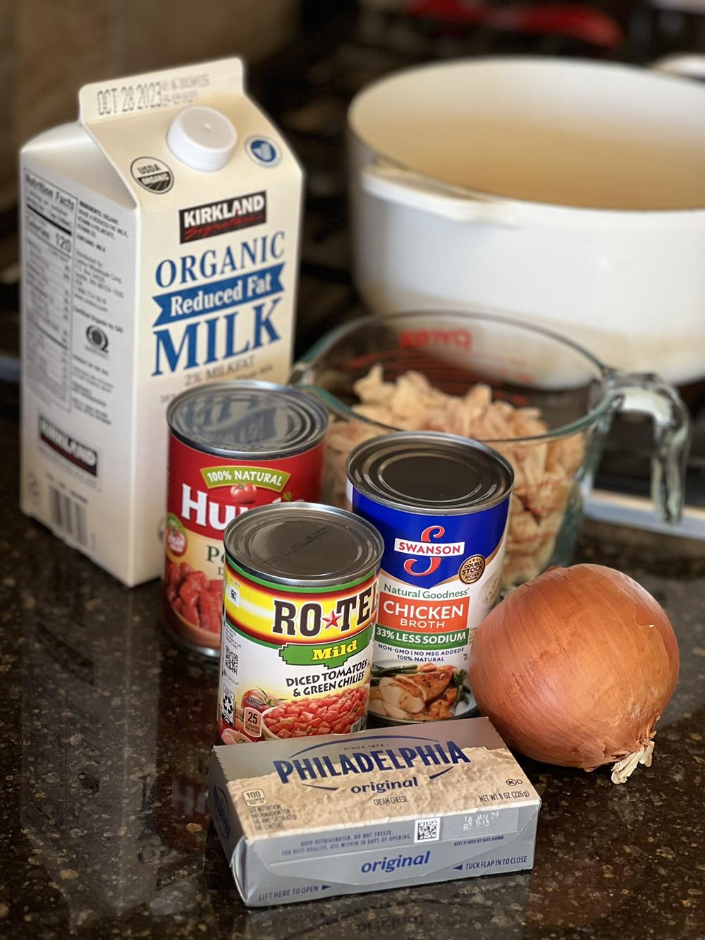 chicken, milk, chicken broth, onion, canned tomatoes next to a soup pot