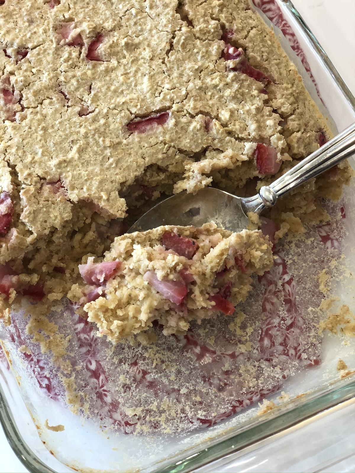 baked oatmeal with strawberries with spoon in glass dish