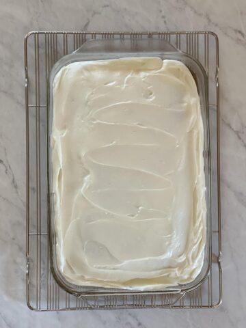 Gluten Free Zucchini Cake with Cream Cheese Frosting in glass pan on wire cooling rack