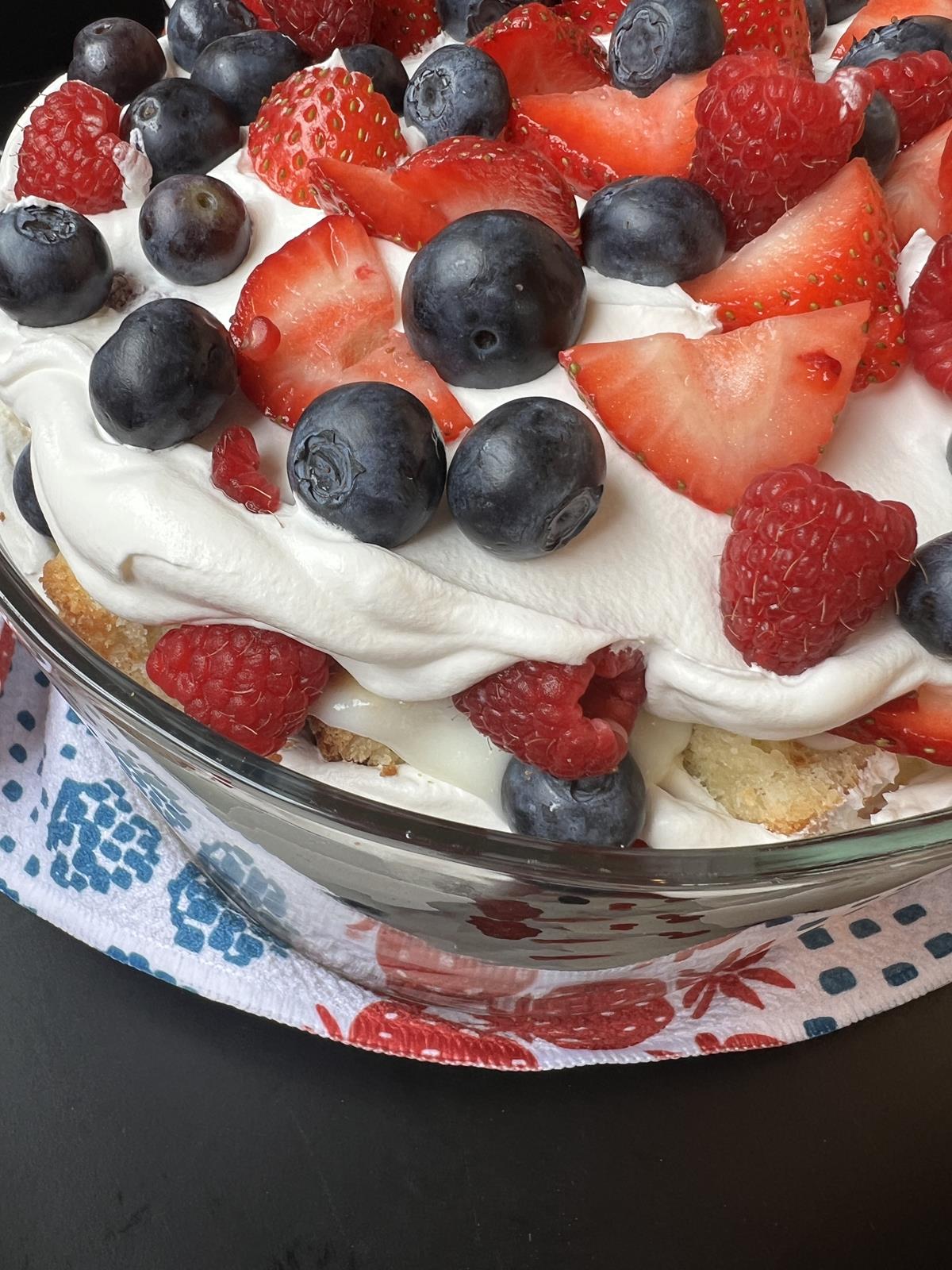 berries, pound cake, pudding, and cool whip layered in a glass bowl