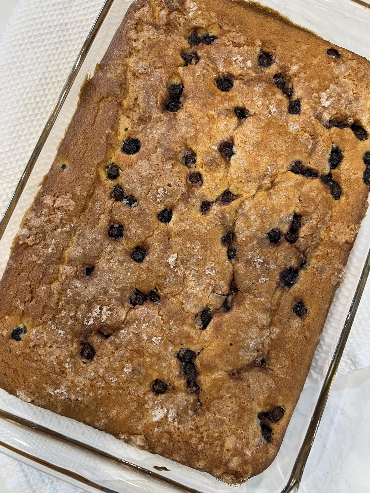 gluten free blueberry coffee cake in glass pan on white background