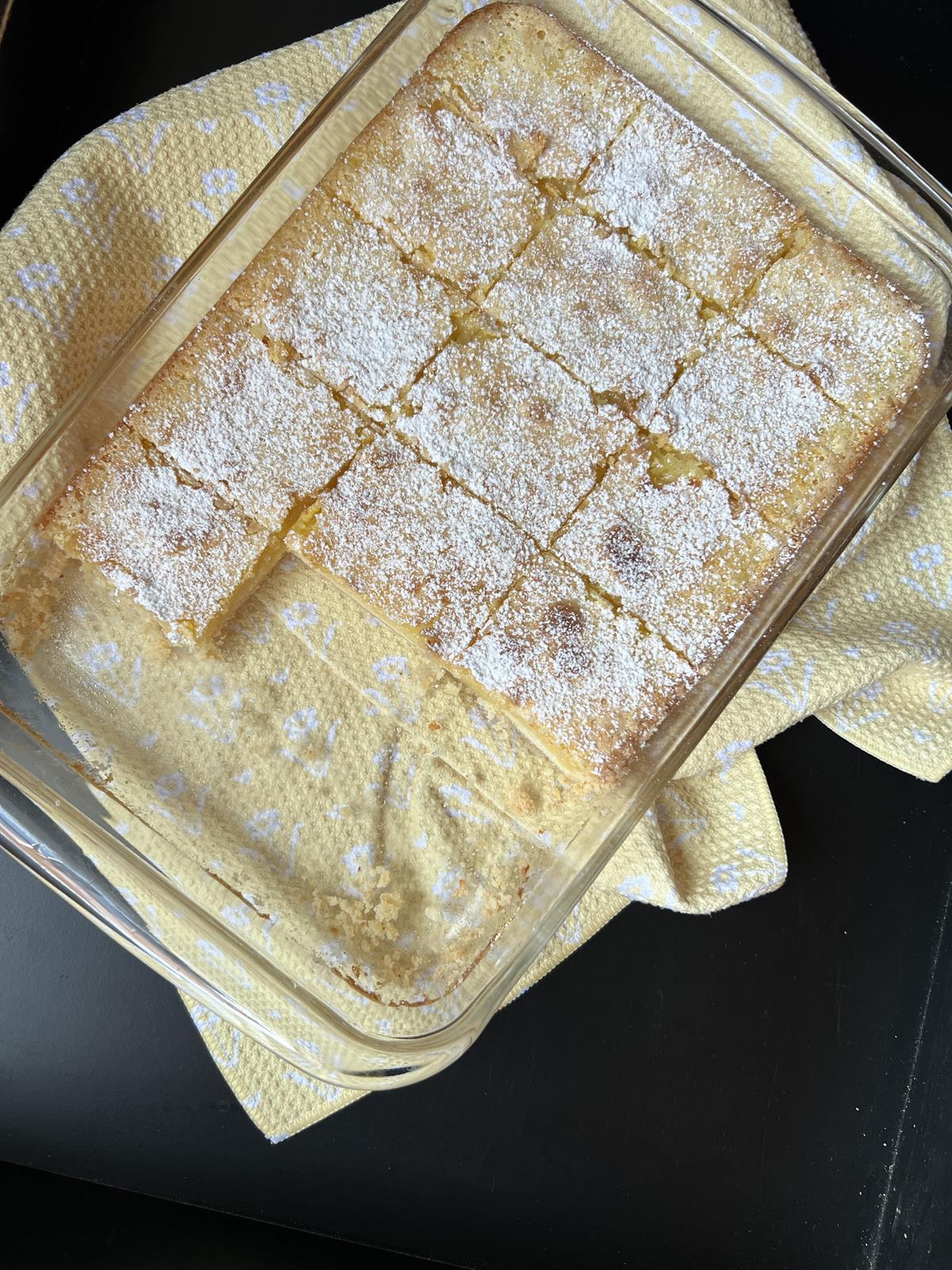 glass pan of gluten free lemon bars on yellow napkin