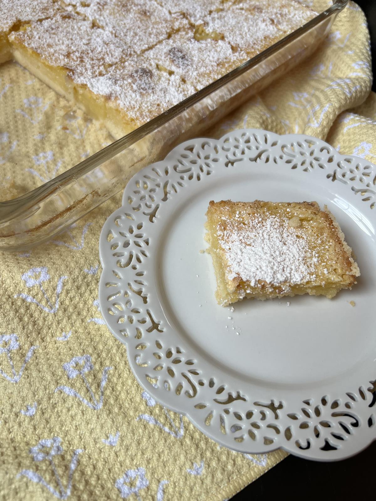 gluten free lemon bar on white plate on yellow napkin