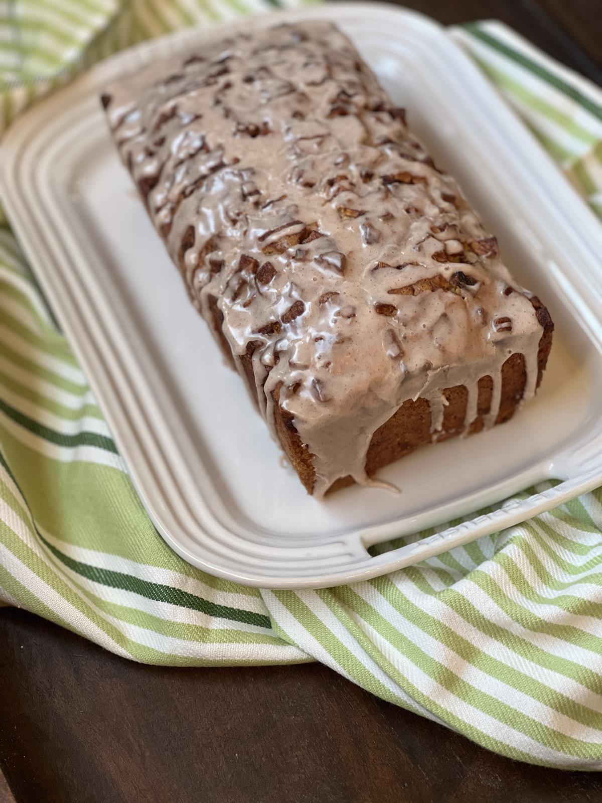 Gluten Free Apple Fritter Bread with glaze on white plate with green and white napkin