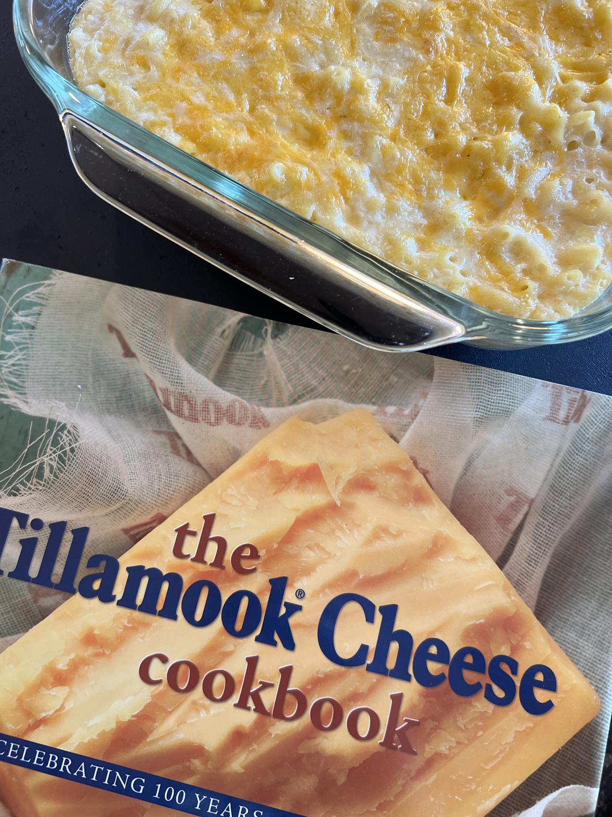 The Tillamook Cheese Cookbook with mac and cheese in background