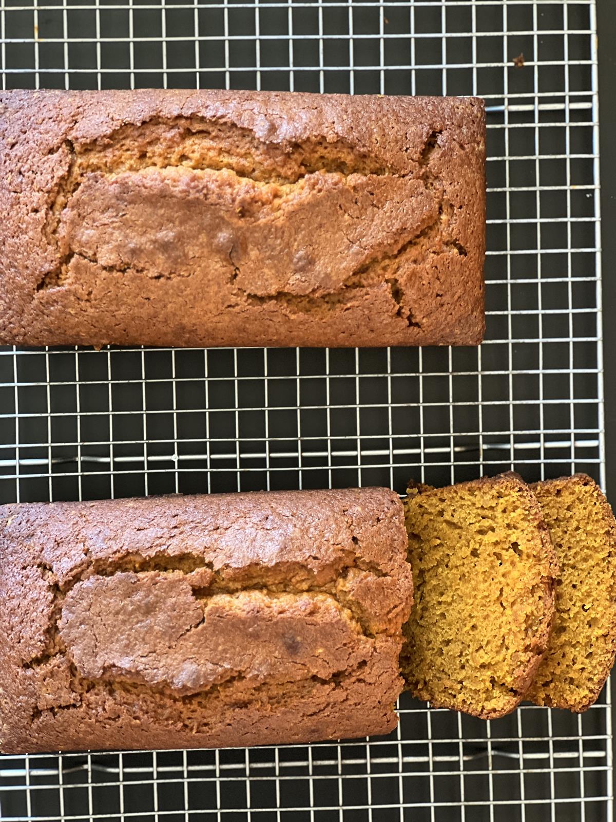 pumpkin bread loaf and slices of pumpkin bread on cooling rack