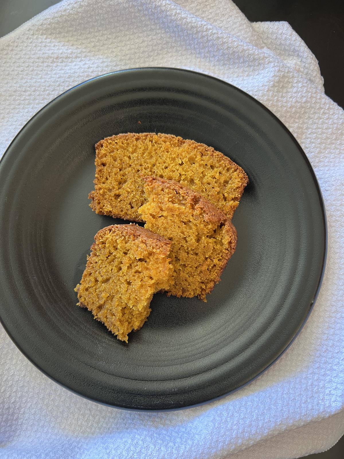 slices of pumpkin bread on black plate with white napkin