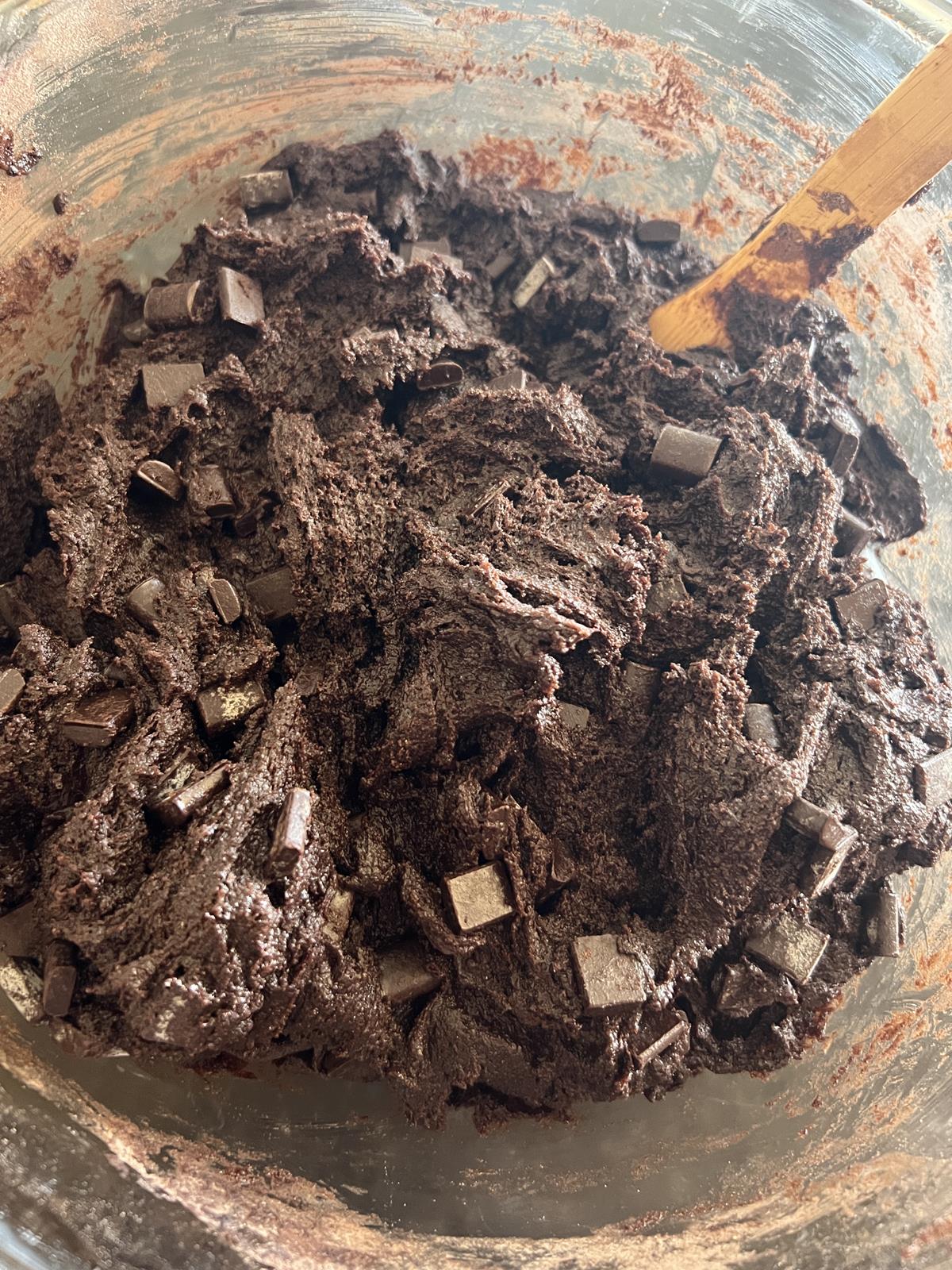 double chocolate cookie batter in glass bowl with wooden spoon