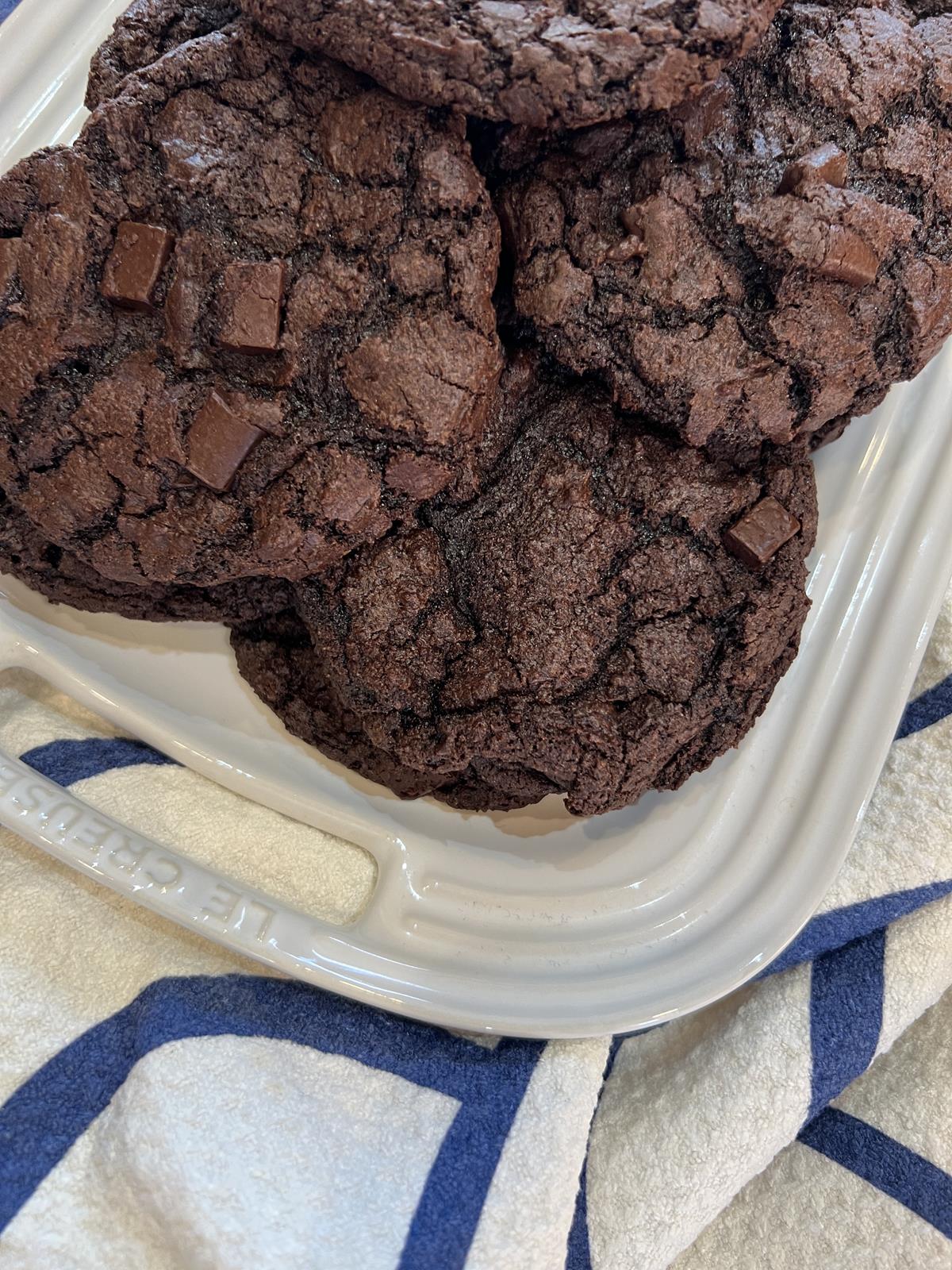 milk chocolate cookies on white platter with blue and white napkin