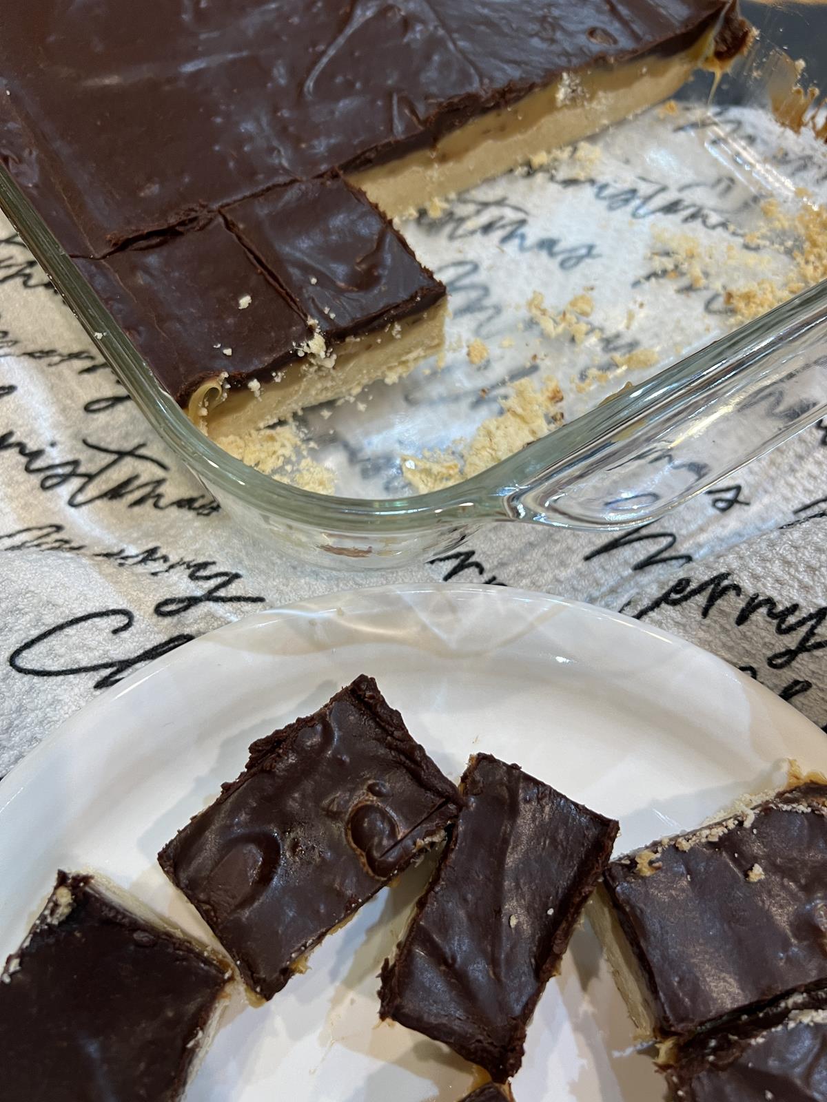 Chocolate Caramel Shortbread Bar in pan with white plate full of bars