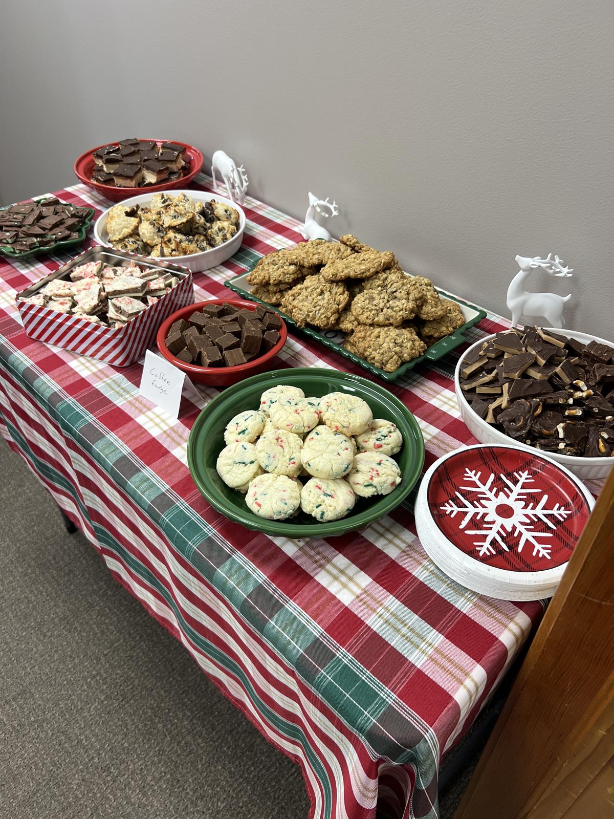 table with red, white, and green table cloth full of Christmas desserts