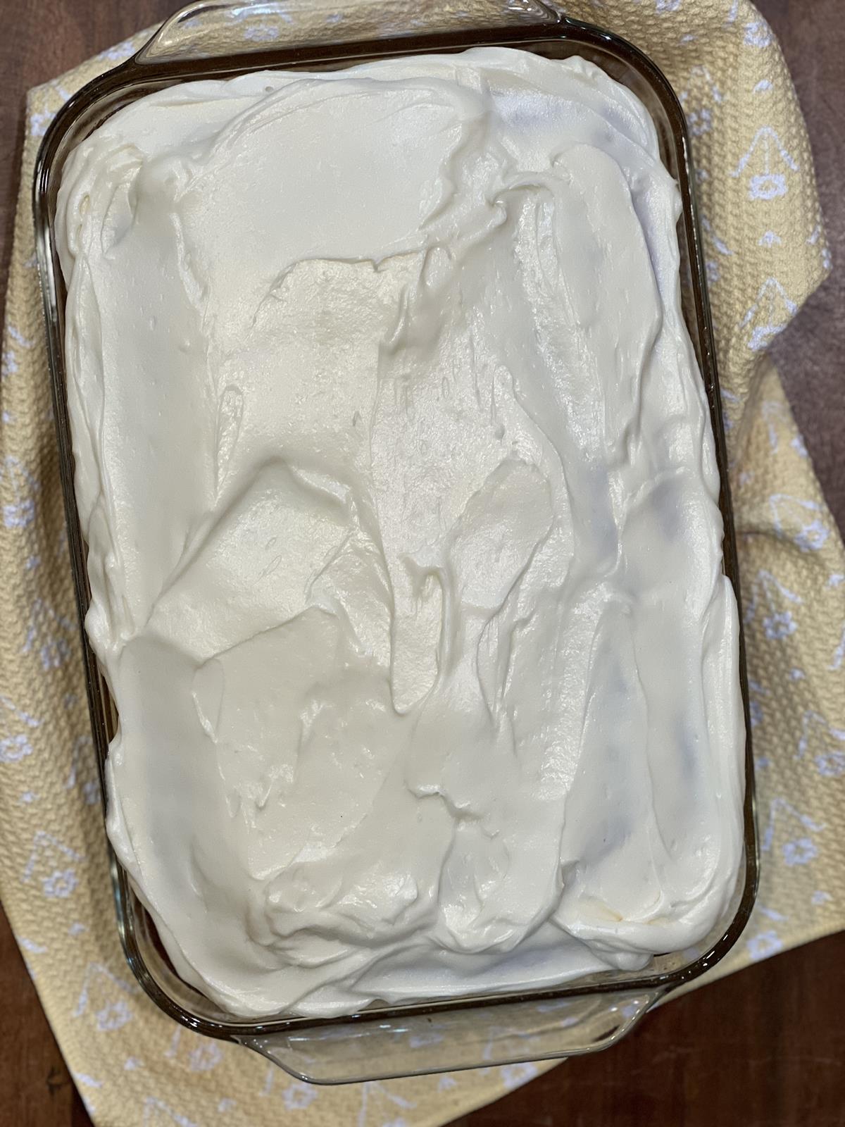 banana cake with frosting on yellow and white napkin