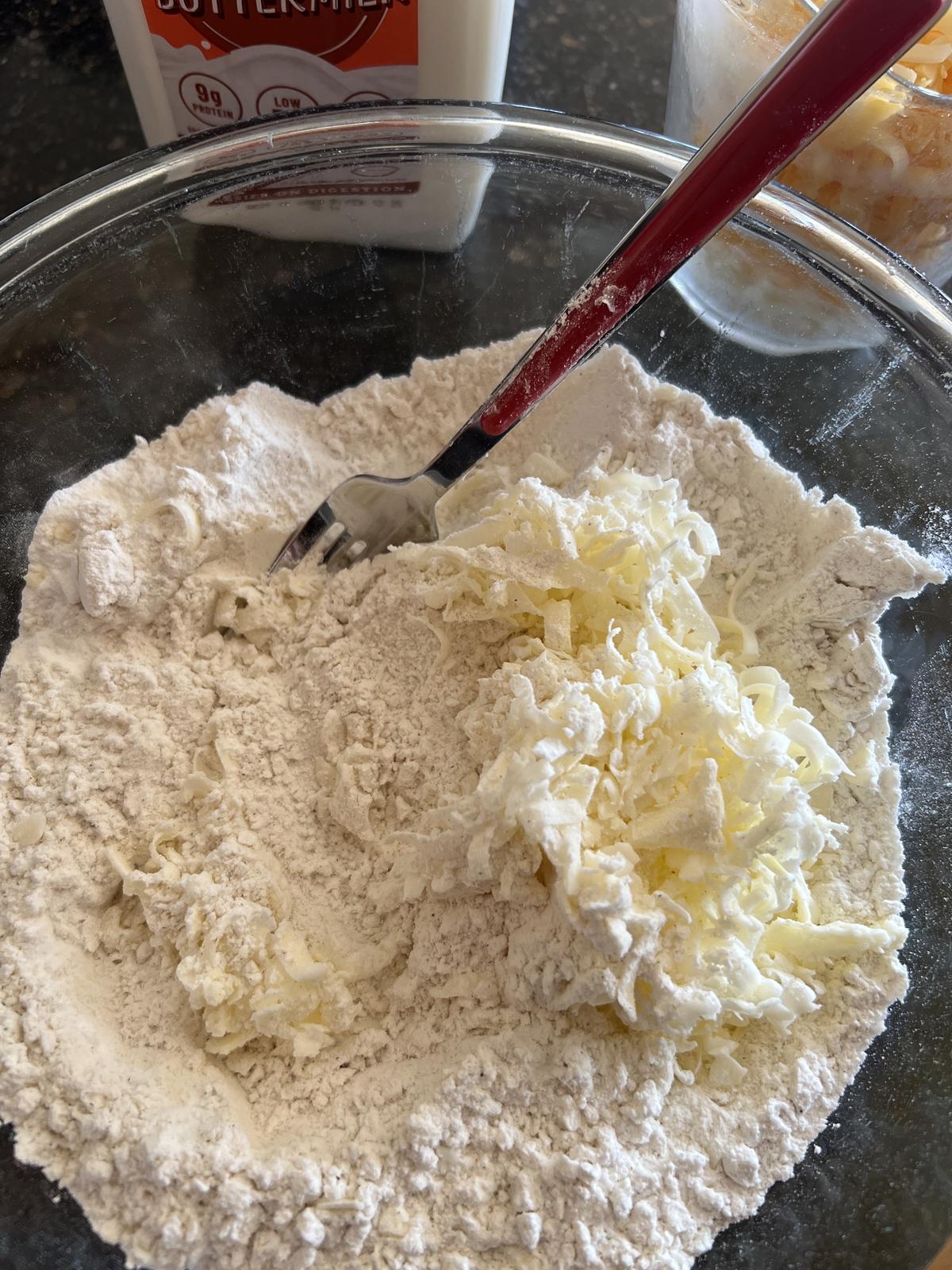 flour, cheese, and butter in glass bowl for soda bread