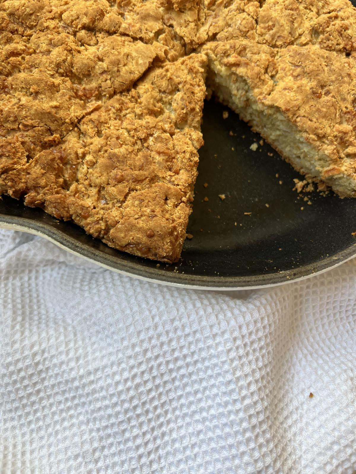 Soda Bread with Sharp Cheddar Cheese in cast iron pan on white napkin