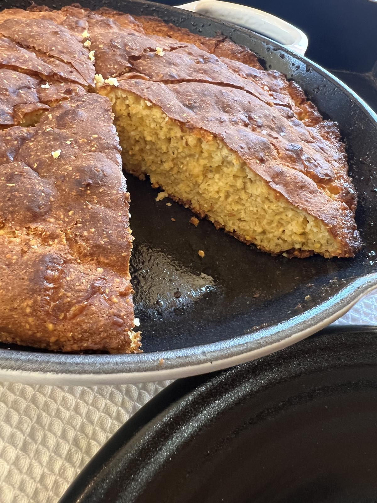 Martha Stewart Cheddar Cornbread Recipe in cast iron skillet on white cloth