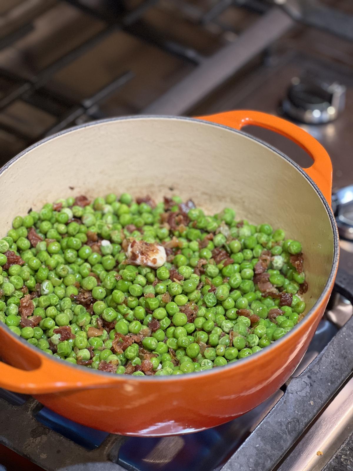 peas, bacon, and onions cooking in pan on stove